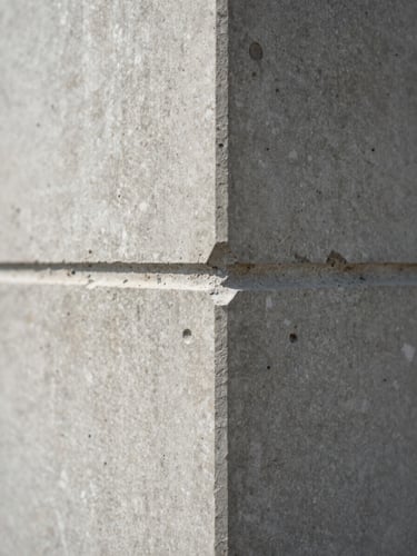 Extreme close-up of raw concrete architectural joints, soft diffused daylight revealing material texture