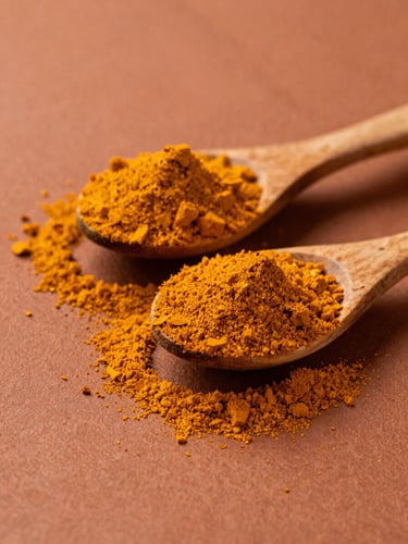 Macro texture of raw vibrant turmeric and chili powders piled on rustic wooden spoons, warm high-contrast side lighting, rich terracotta tones