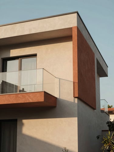 Warm architectural photography of a modern home facade, soft late-afternoon sun casting long shadows, clean lines, terracotta accents, 35mm