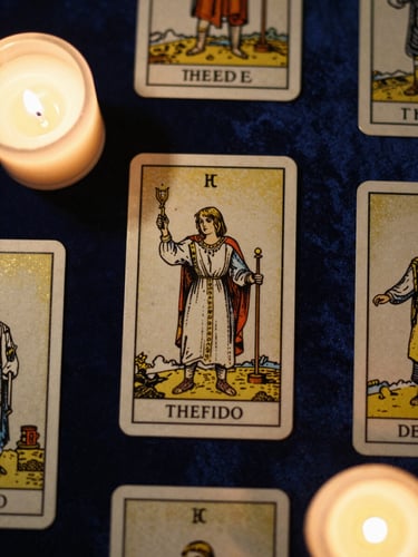 Top-down flat lay of elegant gold-foiled tarot cards on dark blue velvet, soft candlelight casting warm shadows, mystical atmosphere, macro photography