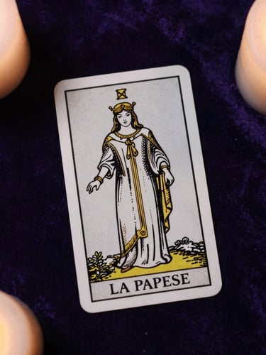Top-down flat lay of the classic Tarot de Marseille card 'La Papesse' with delicate gold line art details, resting on dark purple velvet under soft candlelight, casting elegant long shadows.