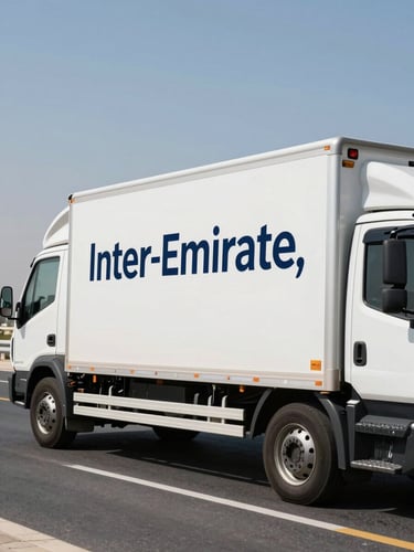 A clean, white moving truck with professional navy branding parked on a bright UAE highway under clear daylight, representing inter-emirate transit.