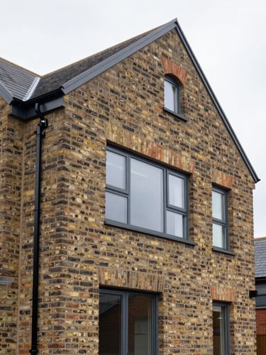 Crisp architectural photography of a modern brick house extension in Manchester, seamless integration with original brickwork, bright overcast daylight, sharp focus, 35mm