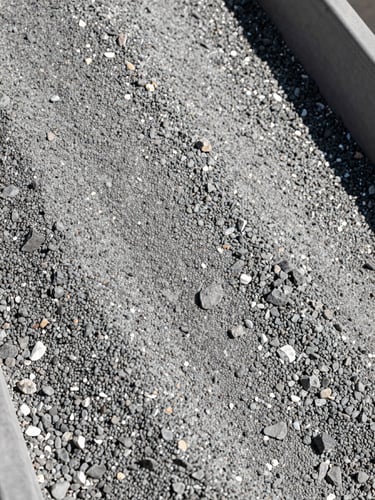 Close-up of a vibrating screen sorting gravel by size, sharp high-contrast rock textures, bright sunlight, industrial photography