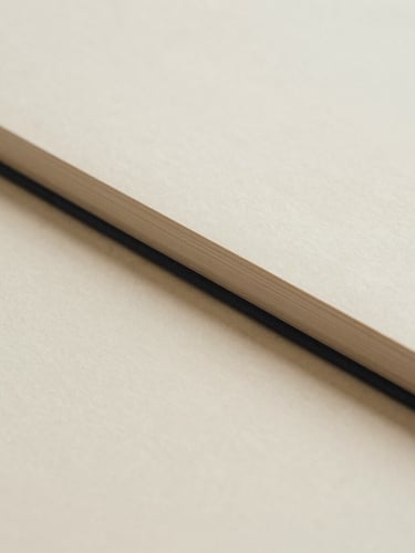 Abstract composition of clean paper textures and elegant closed book spines, soft diffused morning daylight, neutral beige tones, minimalist aesthetic