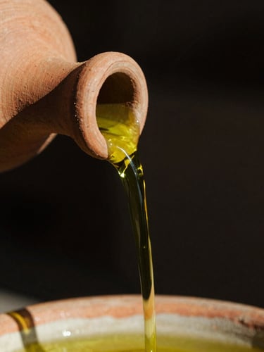 Extreme macro shot of thick, vibrant green olive oil pouring from a raw clay spout, high-contrast sunlight, deep shadows, 35mm film