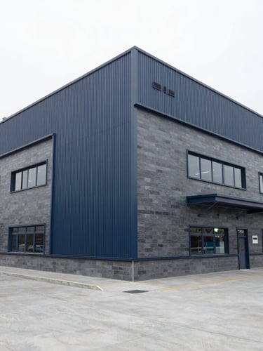 Wide environmental shot of a modern clean industrial facility with structured architectural lines, bright overcast daylight, cool slate tones, 35mm lens.