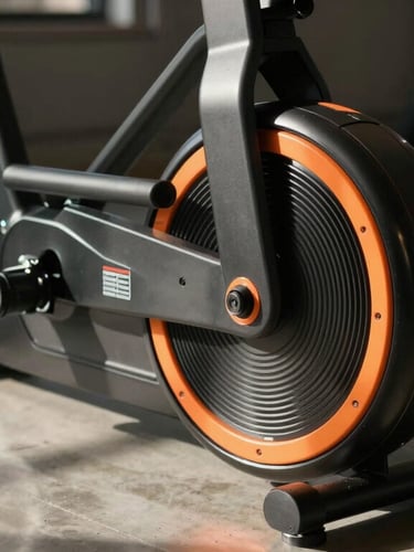 Tight close-up of a high-end indoor trainer flywheel with kinetic orange accents, dramatic side lighting casting long shadows on concrete floor.