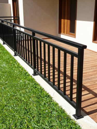 Crisp architectural photography of a modern Kuwaiti villa yard, featuring lush green artificial turf contrasted against a sleek matte black iron railing, bright harsh daylight, sharp focus, 35mm