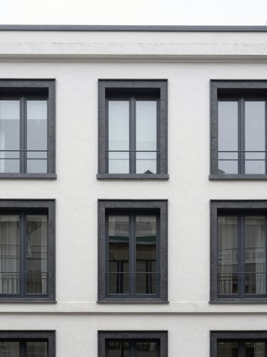 Straight-on architectural elevation of a modern Brussels townhouse facade, crisp white rendering meets dark slate frames, natural overcast daylight, sharp focus