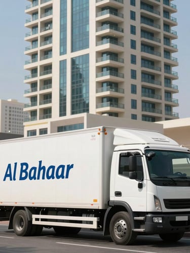 Branded Al Bahaar moving truck parked outside a modern, high-rise residential tower in Abu Dhabi during bright, controlled daylight, showcasing clean logistics execution.