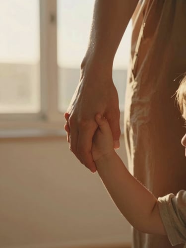 Intimate close-up of a parent holding a child's hand, soft golden-hour backlighting, natural indoor window light, warm tones, authentic interaction