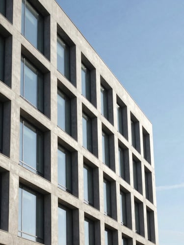 Crisp architectural lines of a modern concrete and glass corporate office building, sharp angles, bright natural daylight, negative space.
