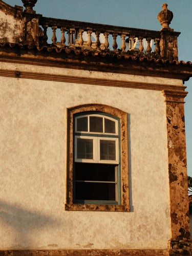 Warm editorial photography of a close-up architectural detail of a historic building in Três Lagoas, old textured wall, golden hour light, 35mm film style.