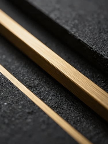 Dramatic low-key macro shot of brushed gold architectural lines cutting through dark obsidian stone shadows, elegant editorial photography, sharp depth of field