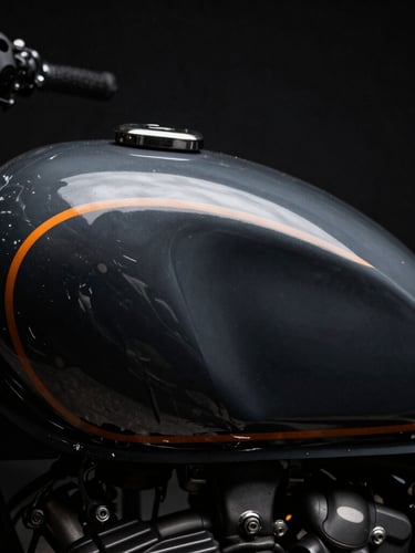 Macro shot of custom-painted vintage motorcycle tank reflecting dark studio lights, deep charcoal tones, sharp orange rim light.