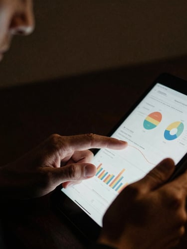 Cinematic close-up of a discerning male professional reviewing detailed analytics on a tablet, low-key lighting, deep charcoal and gold tones, high contrast, 35mm film grain, focus on hands and screen, shallow depth of field.