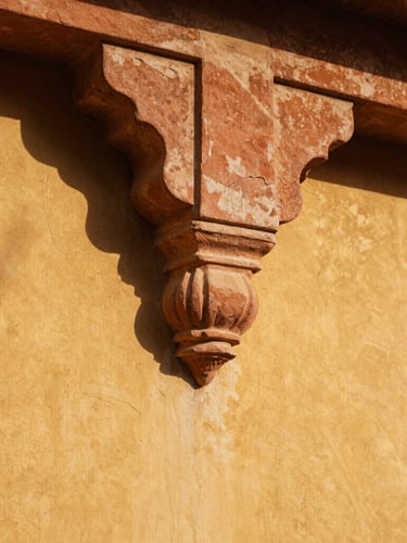 Extreme close-up of hand-carved Jaisalmer sandstone joint, golden-hour tropical sunlight casting deep geometric shadows across textured lime plaster.