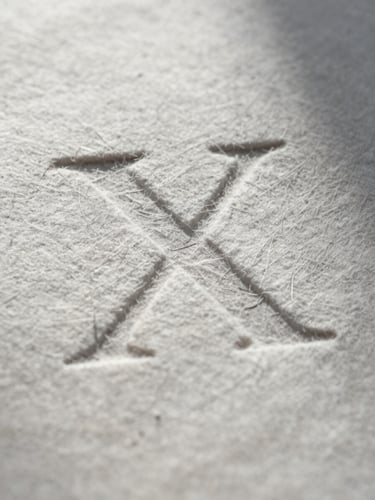 Extreme macro close-up of heavy cotton paper showing deep letterpress indentation and architectural shadow casting across the grain.