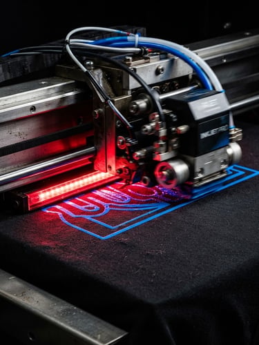 Macro portrait of an industrial DTF printer in motion, electric blue ink curing on black cotton fabric under intense red studio rim light, sharp technical details, 3:4 portrait crop