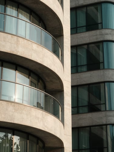 Abstract architectural details of a modern financial hub, concrete and glass curves, soft morning light, deep forest green tones, minimal composition