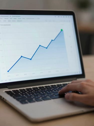 Close-up of a laptop screen showing a clean analytics chart with a gentle upward line in blue and a small green milestone marker, a hand resting near the trackpad in soft focus, cool ambient studio light, minimal desk surface visible