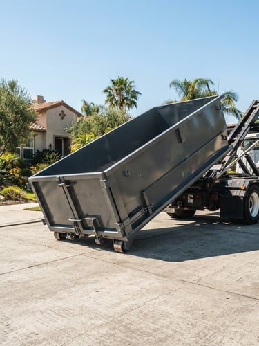 Low-angle wide shot of a clean steel roll-off dumpster being lowered onto a residential driveway in bright California daylight, crisp shadows, 35mm lens.