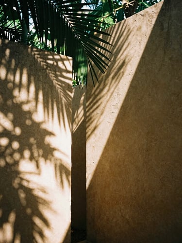 Warm editorial photography, dappled jungle sunlight filtering through palm leaves onto raw chukum walls, 35mm film aesthetic, architectural detail.