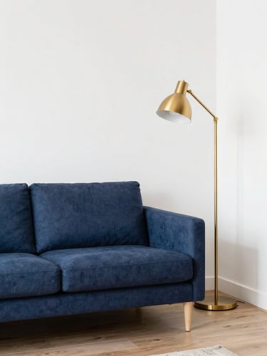 Bright shared living room with natural light, tidy navy blue sofa, gold floor lamp, and structured layout, 35mm interior photography