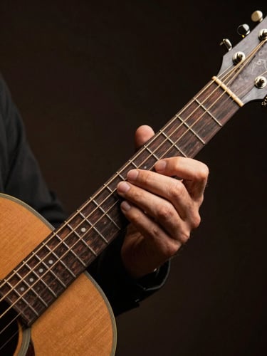 Close-up of a guitarist's left hand pressing chord on an acoustic guitar neck under a single studio key light, warm golden glow on worn fretboard, deep shadow falling right, dynamic angle suggesting movement mid-strum