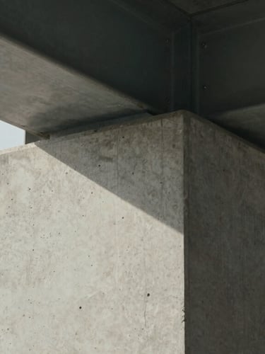 Close-up of a flawless concrete column joint meeting a steel beam, minimalist architectural detail, bright natural daylight emphasizing texture, straight-on framing