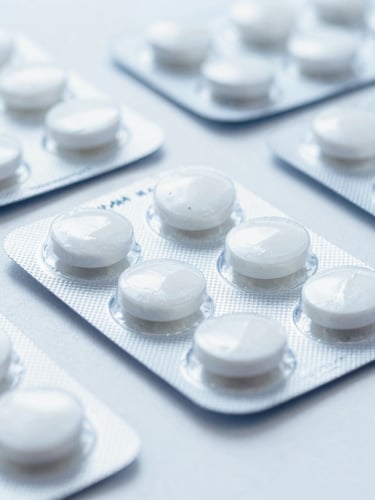 Macro shot of sterile pharmaceutical blister packs on a clean white surface, bright clinical lighting, cool blue tones, sharp focus, 50mm lens