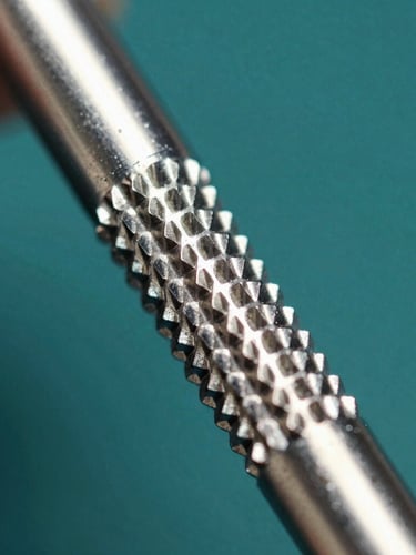 Extreme close-up of surgical steel knurling under hard key light, sharp metallic reflections, sterile laboratory background