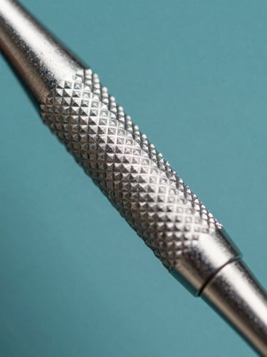Extreme macro close-up of a textured metallic dental instrument handle, sharp knurling detail, sterile silver reflections, high-contrast studio key light, cool silver tones