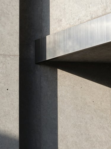 Abstract portrait close-up of premium raw concrete and brushed steel architectural details, dramatic natural shadows, clean morning light.