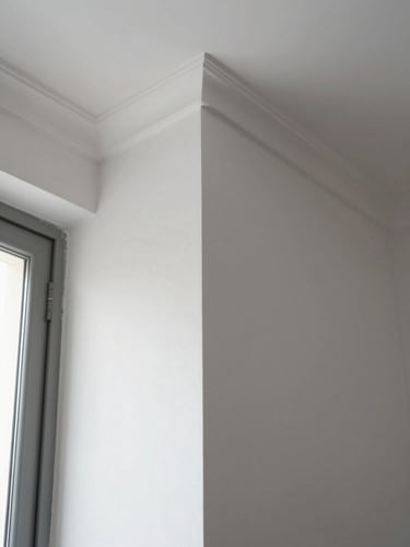 Close-up of a freshly painted interior wall corner in Buenos Aires apartment, crisp edge trim where wall meets ceiling, flat matte white paint surface under natural window light, no people, documentary framing