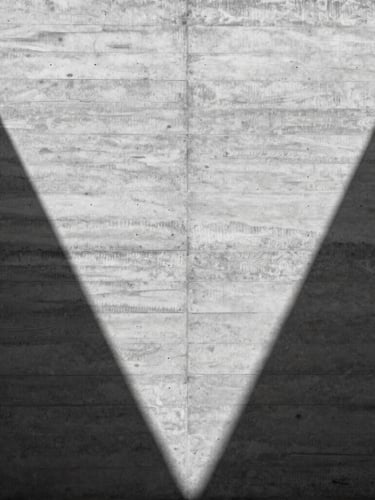 Symmetrical composition of a raw concrete wall with sharp geometric shadows, harsh midday sun highlighting timber board-marked textures, architectural detail, minimalist 35mm photography