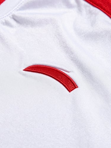 Close-up of highly textured athletic fabric with clean custom embroidery, bright natural lighting, sharp focus on stitching