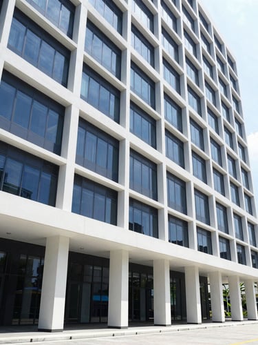 Professional corporate photography, bright natural office light, a modern office building exterior in Ampang, Selangor, with clear architectural lines, clean navy and white tones, sharp focus, 35mm, wide shot, low horizon