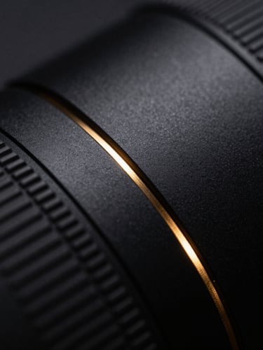 Macro close-up of sleek matte black tech surfaces with a single sharp metallic gold light leak, dark editorial photography, 35mm lens, dramatic low-key lighting