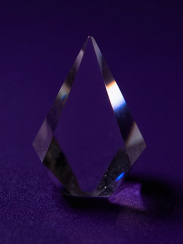 Macro close-up of light refraction through a crystal prism on a deep violet surface, high contrast chiaroscuro, 35mm lens