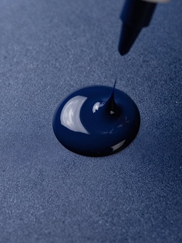 Macro detail of liquid ink curing under ultraviolet light on a textured matte substrate, sharp studio lighting, high contrast deep navy tones
