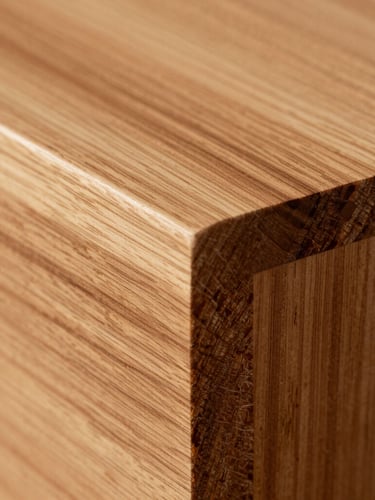 Extreme close-up of custom hand-cut dovetail joinery in premium quarter-sawn elm, warm natural oil highlighting the deep amber grain