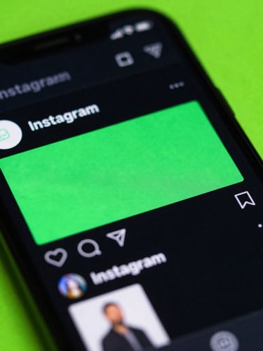 Tight macro shot of a mobile screen showing a vibrant Instagram feed mockup with high-contrast neon green graphic overlays, dramatic dark-mode glow, 35mm
