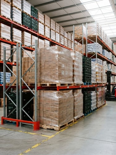 Industrial clean photography of stacked food pallets in a modern high-contrast warehouse, bright daylight, red accents, sharp focus, 35mm