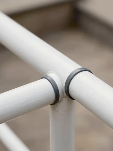 Macro detail shot of pristine white aluminum handrails and perfectly sealed dark gray flashing joints, soft natural daylight, shallow depth of field