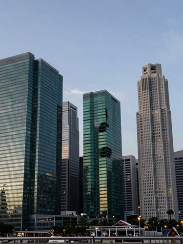Architectural wide-angle shot of Singapore's skyline at twilight, clean geometric lines, high-contrast lighting with deep green tones reflecting off modern glass structures.