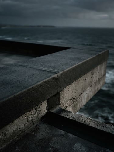 Close-up of a thick, flawlessly applied liquid membrane on a modern concrete balcony edge overlooking the ocean, dramatic low-key lighting, deep charcoal tones, sharp material textures, 35mm film