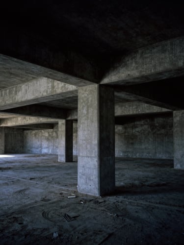 Wide-angle architectural elevation of a concrete basement sub-structure under construction, dramatic shadows, sharp material textures, dark architectural photography.