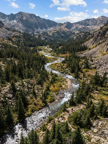 Overhead perspective of a rugged Colorado alpine river basin, sharp details of pine forests and rocky streams under crisp mountain daylight